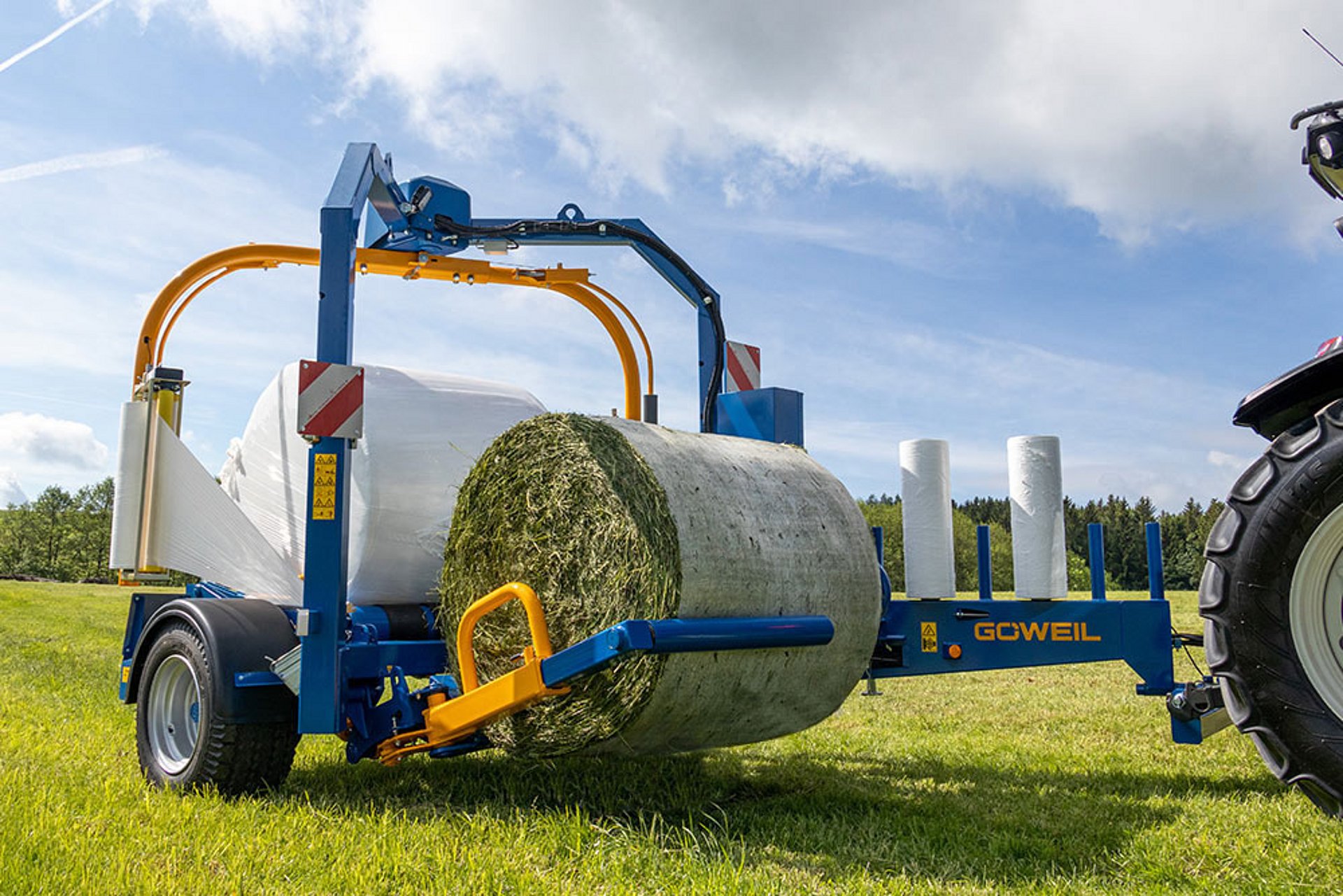 Der hydraulische Ladearm greift den Ballen schonend auf