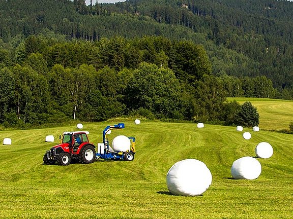 De balen worden na het persen direct op het veld gewikkeld.