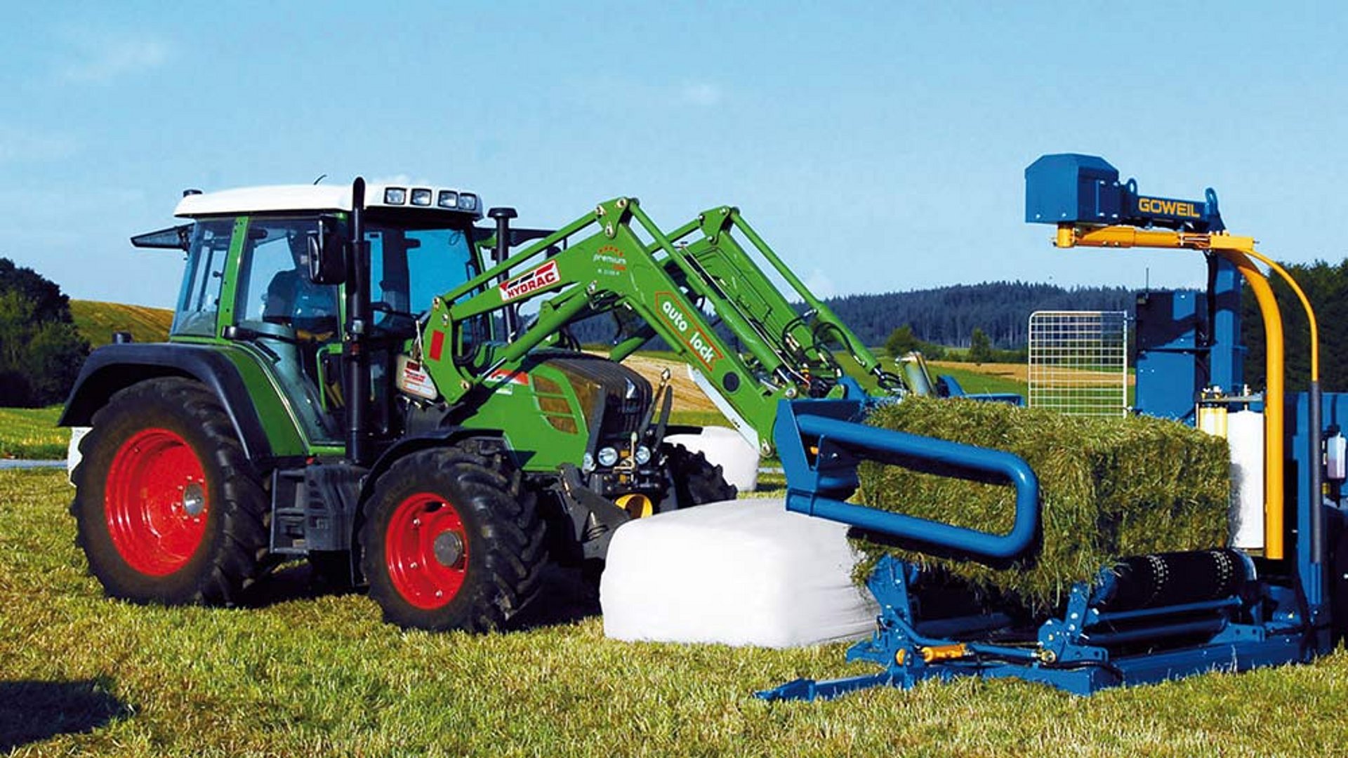 La balle rectangulaire est chargée sur l’enrubanneuse G3010 Q Farmer.