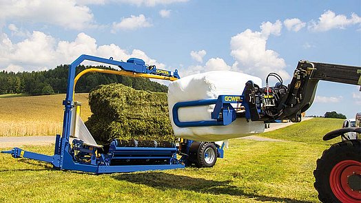 The fully wrapped square bale is hauled away with the BTGQU.