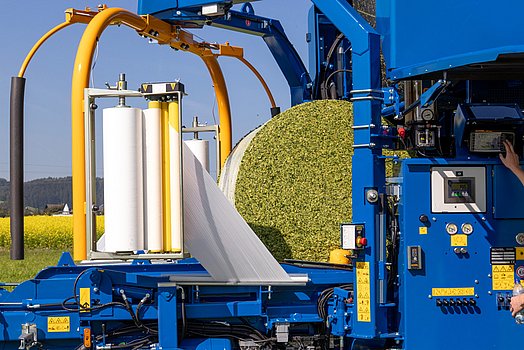 The bale is picked up from the mobile wrapping table.