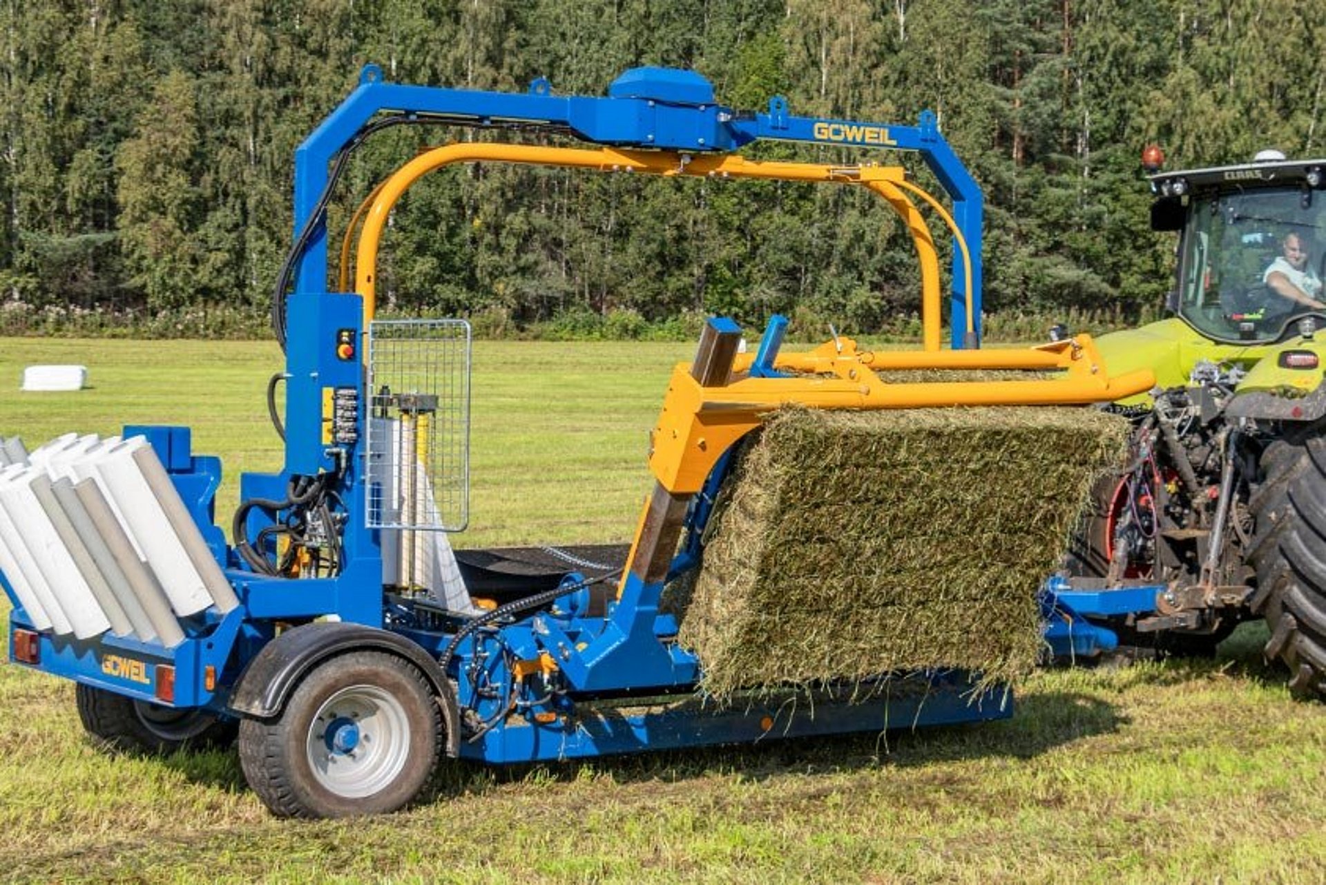 The bale pick-up lifts the square bale onto the wrapping table.