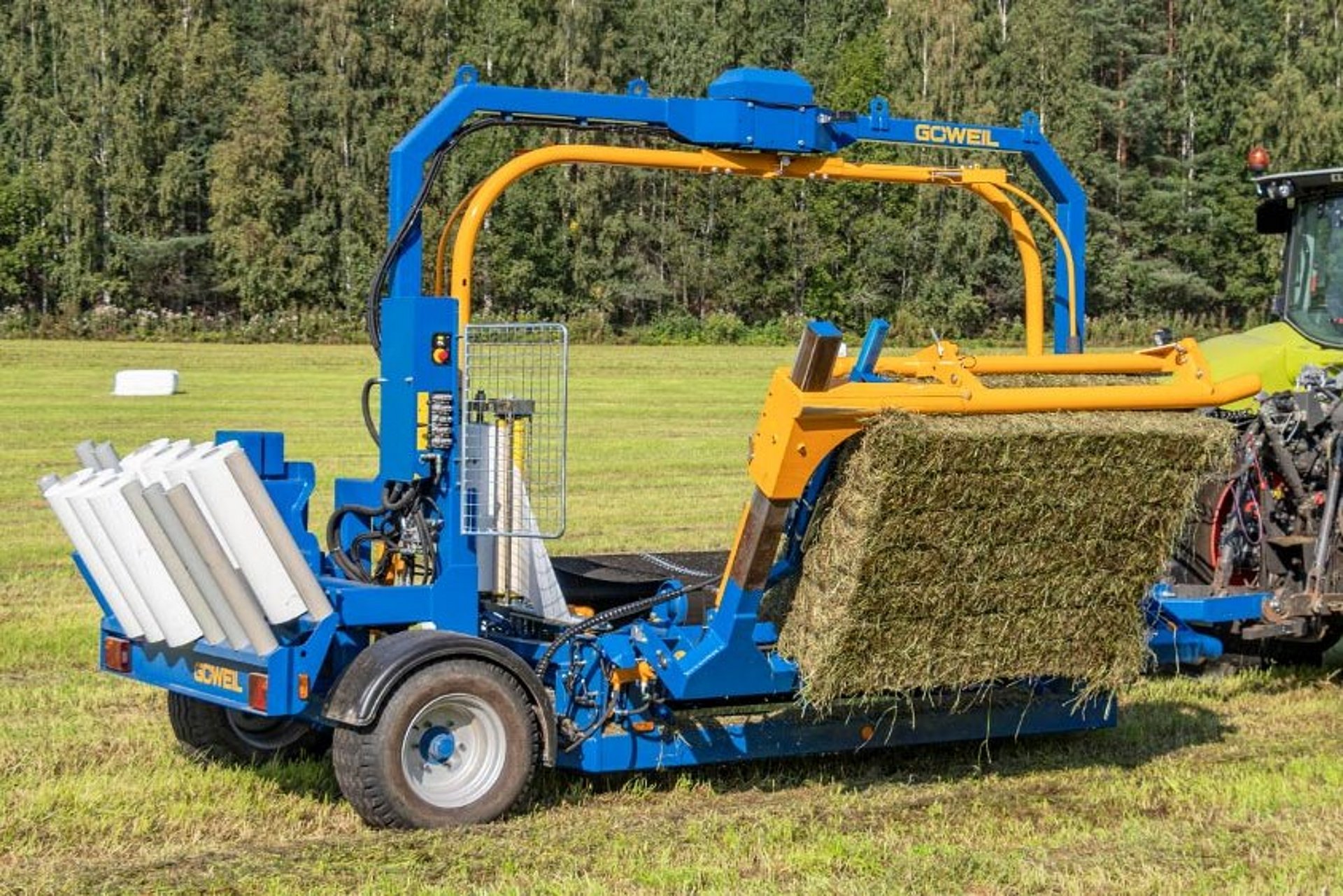 Mit dem Ballenaufnehmer wird der Quaderballen auf den Wickeltisch gehoben.