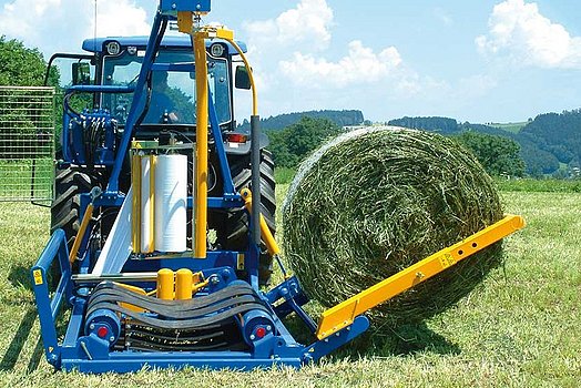 Avec le bras de chargement, la balle est chargée en douceur sur la table d’enrubannage.