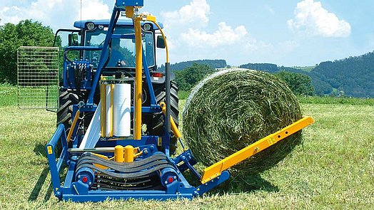Avec le bras de chargement, la balle est chargée en douceur sur la table d’enrubannage.