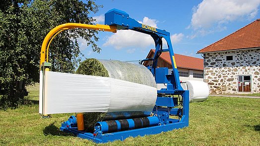 Les quatre courroies de transport garantissent un enrubannage uniforme des balles.
