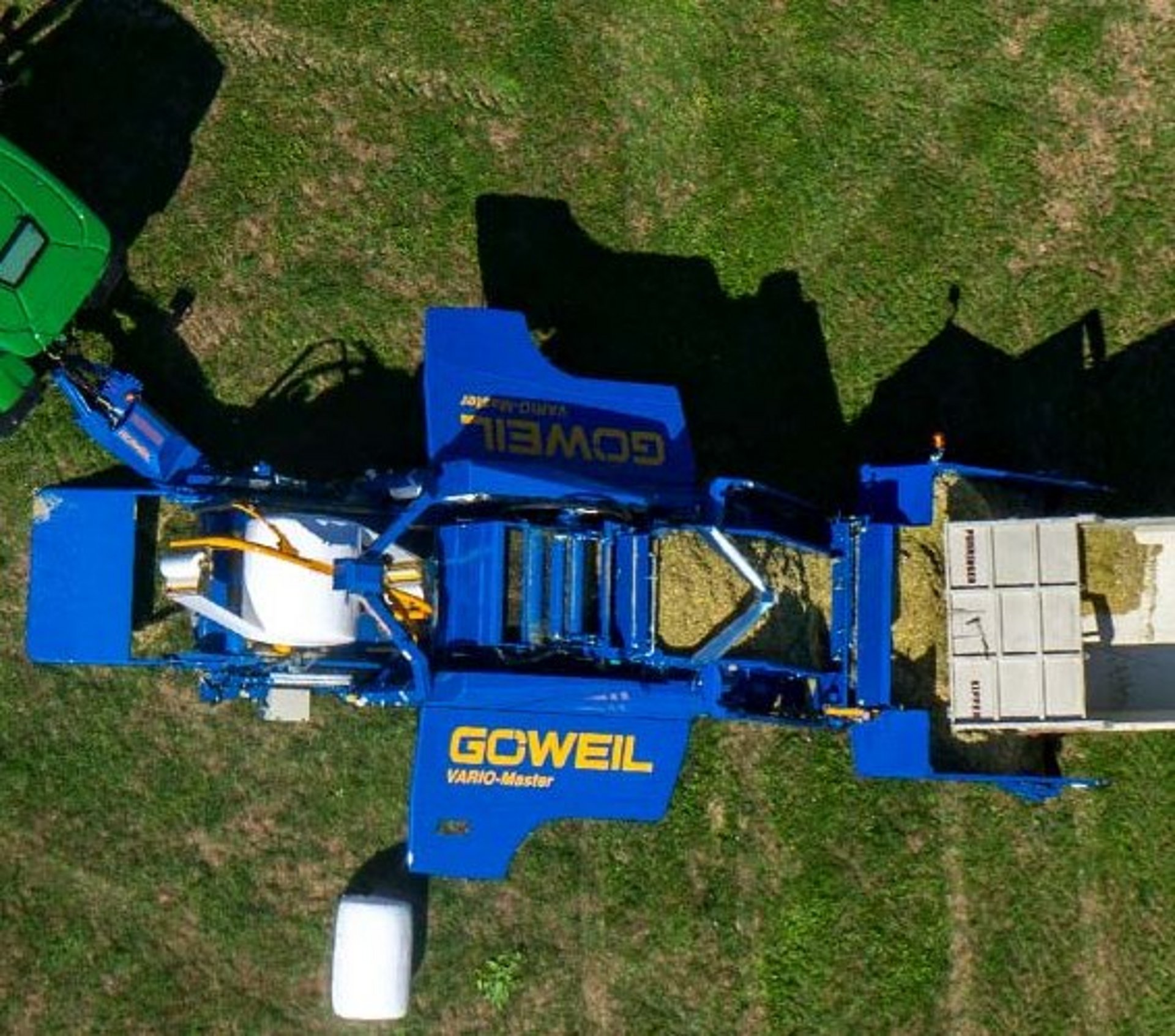 Van de opvoerband valt het materiaal in de perskamer.