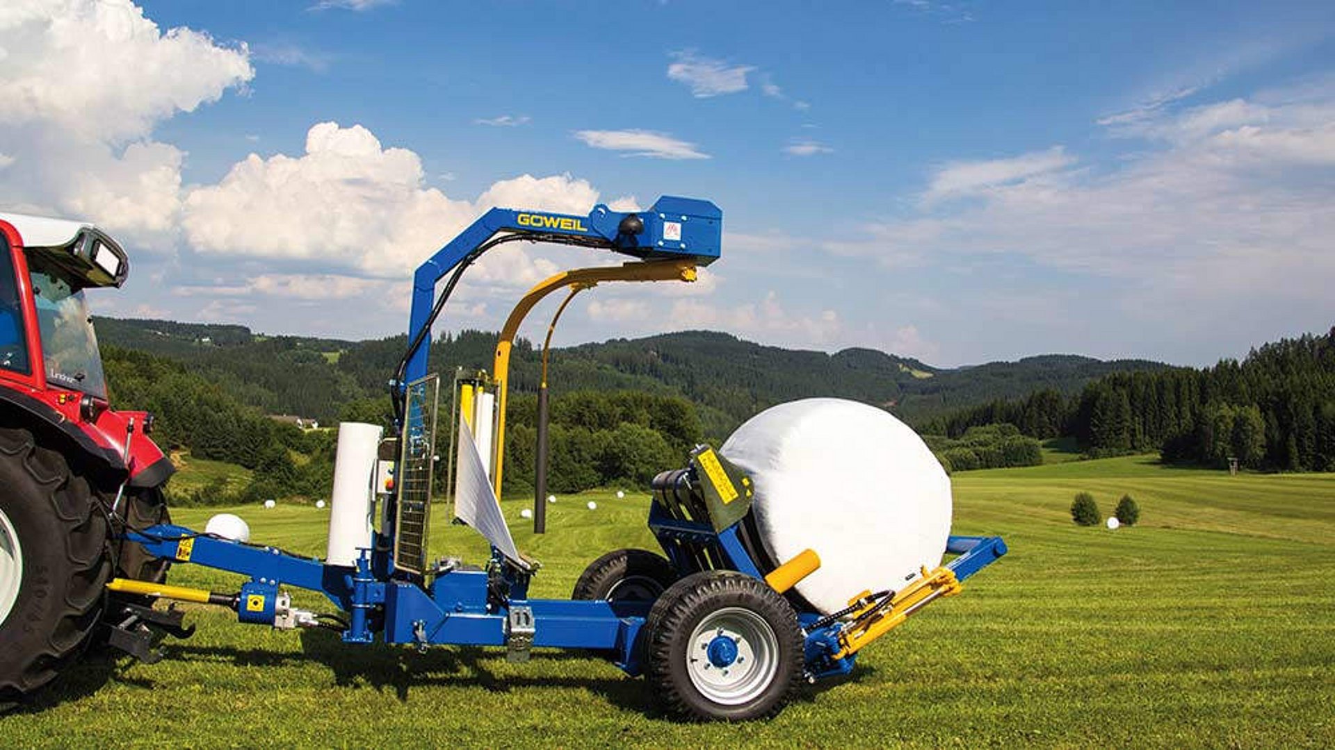 Bij het balen afwerpen gaan wikkeltafel en grijparm gezamenlijk omlaag naar de grond.