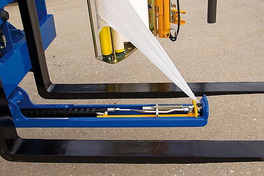 La encintadora para palets G1010 está equipada con un mecanismo automático de corte y aplicación de lámina, abatible por vía hidráulica.