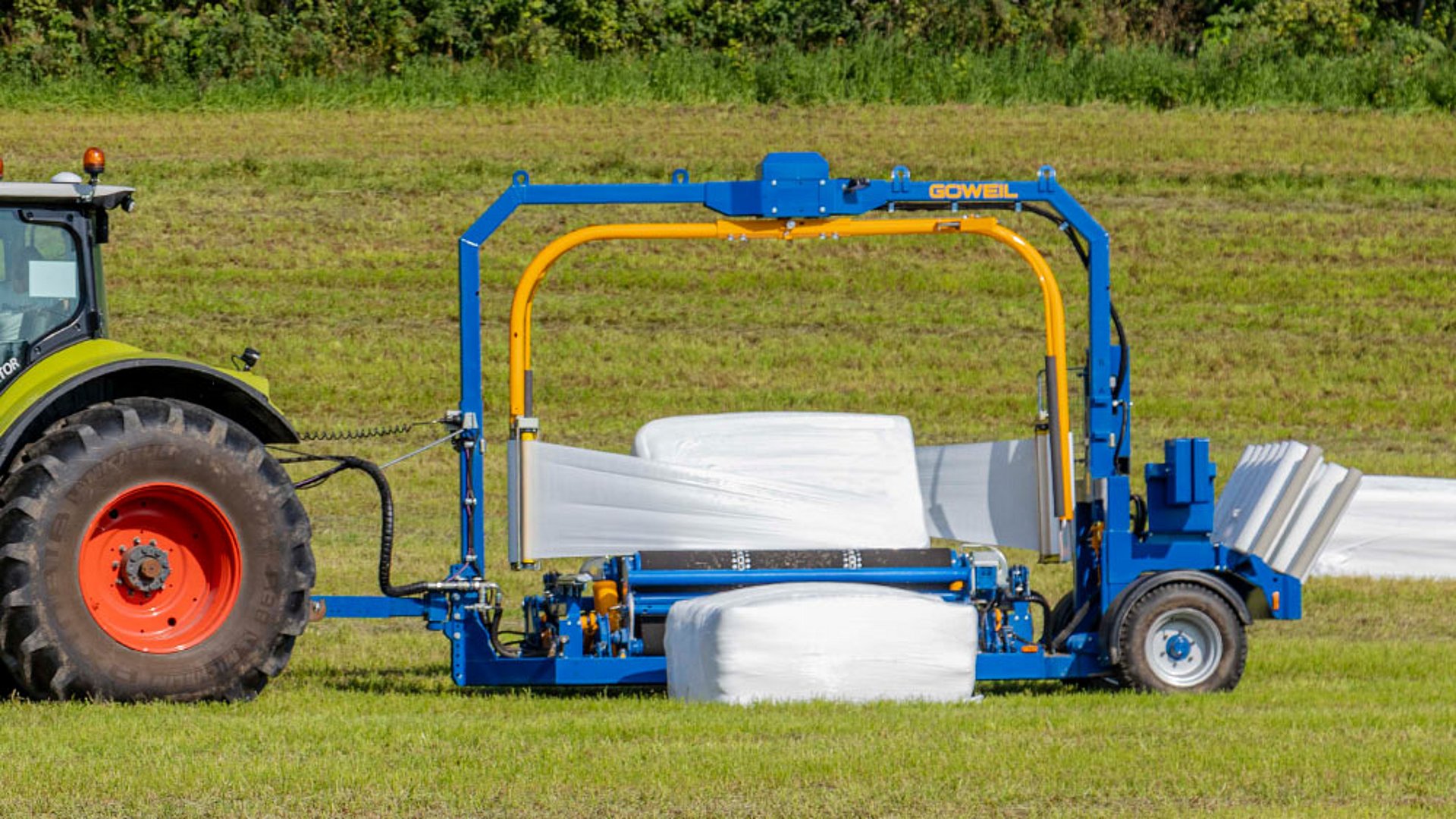 L’enrubanneuse de balles rectangulaires 4020 Q Profi est tractée dans le champ.