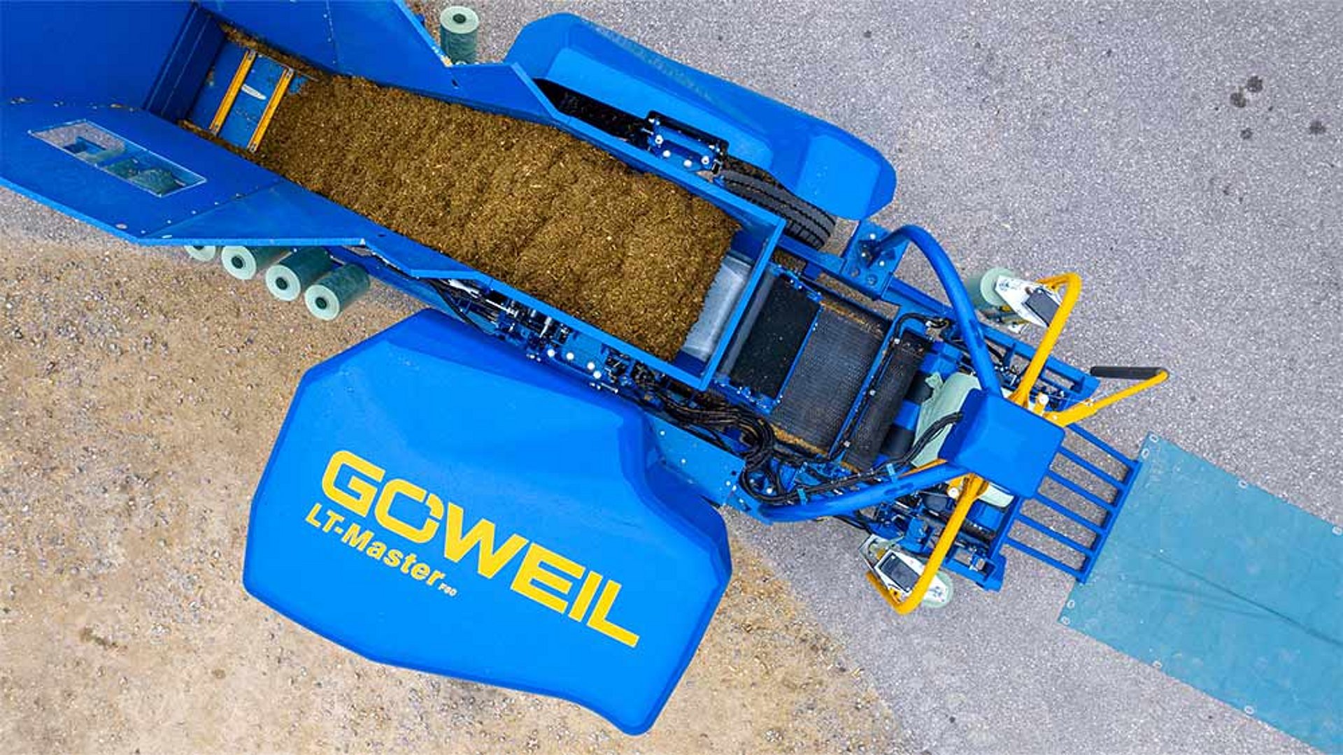 Het materiaal wordt gedoseerd via de steile transportband en naar de perskamer getransporteerd.