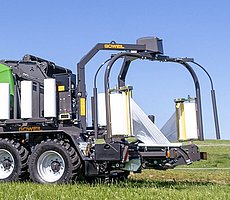 De mobiele wikkeltafel kantelt naar de bodem toe en de baal wordt voorzichtig afgeworpen.