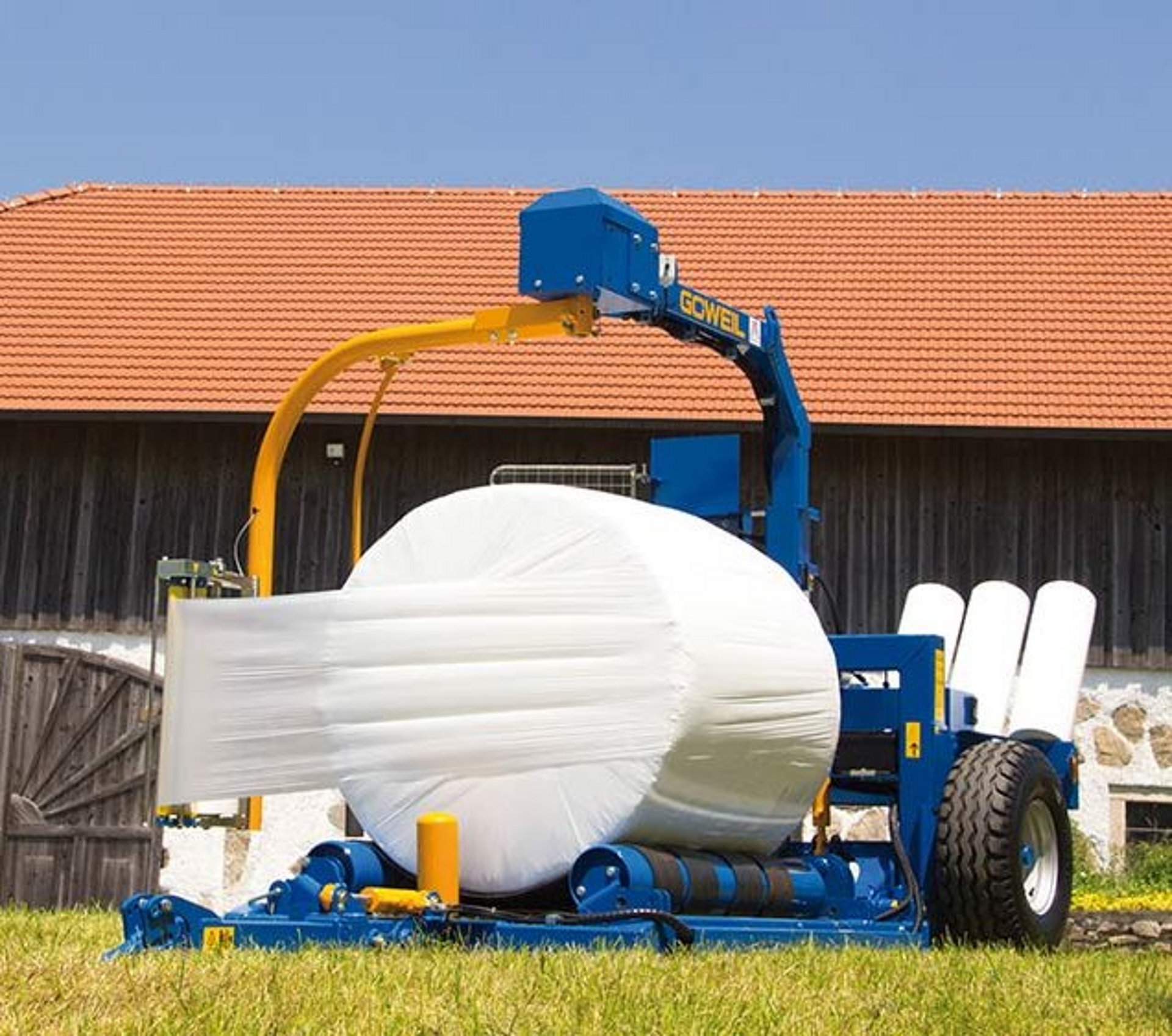 De G3010 Farmer bij het wikkelen van een ronde baal.