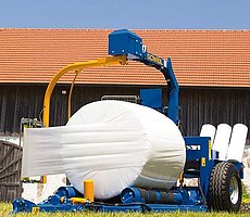 Die G3010 Farmer beim Wickeln eines Rundballens.