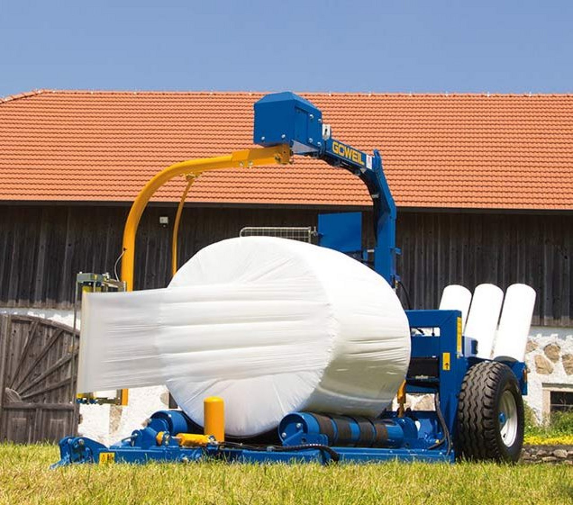 The G3010 Farmer wrapping a round bale.