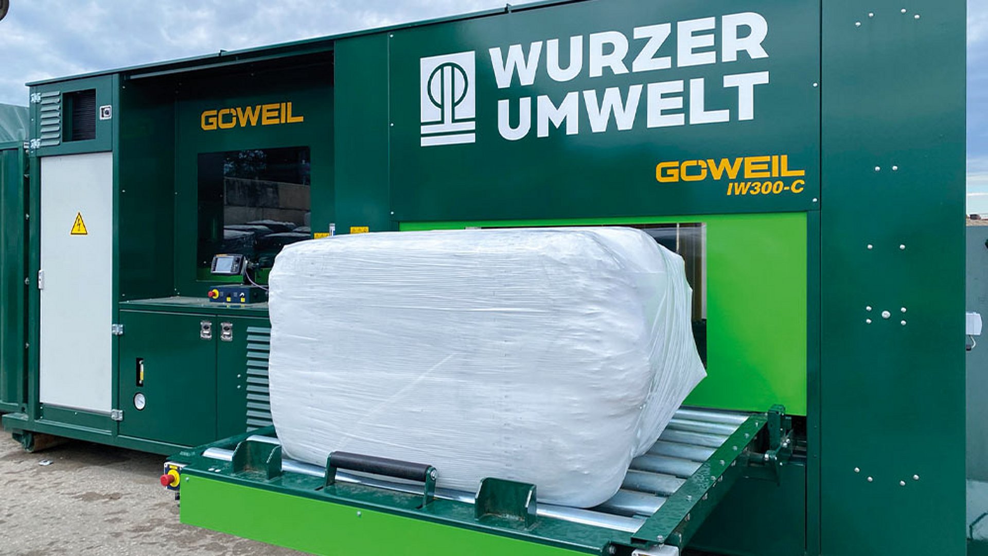 The finished bale is deposited on the hydraulically pivoting conveyor belt for removal.